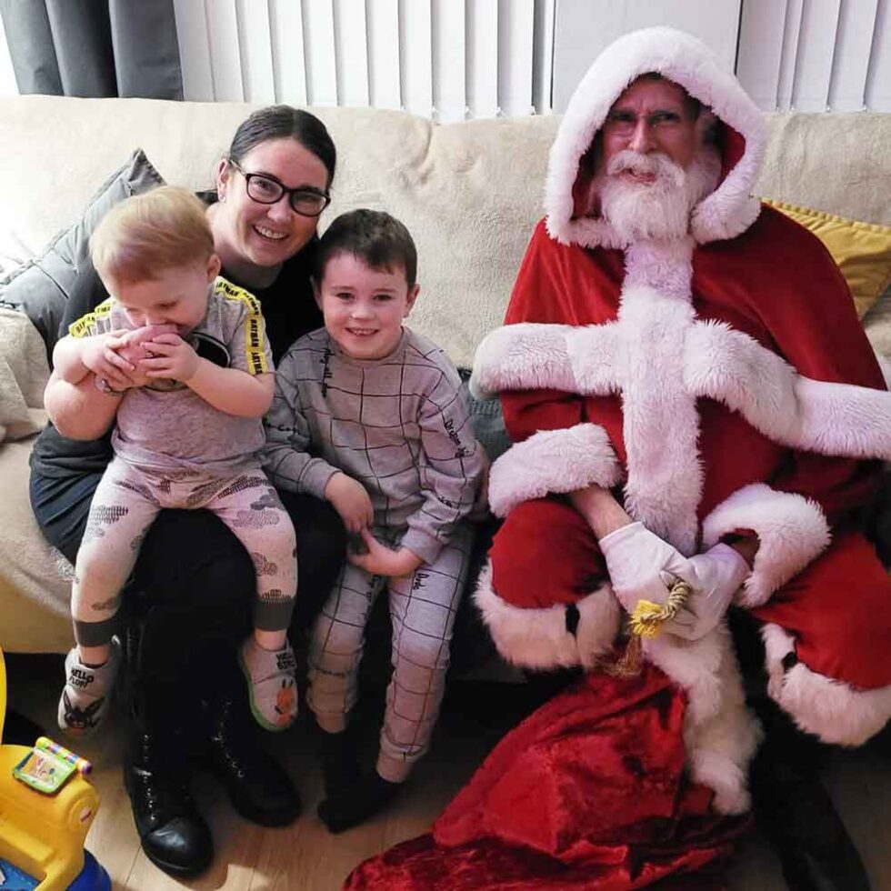 Santa with a mum and two kids at their home