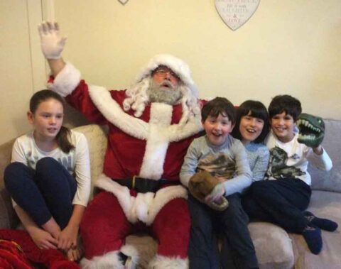 Santa Claus with happy children on a home visit